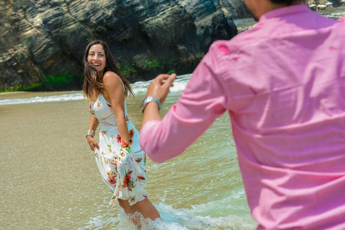 Ella saliendo del agua hacia él, que le tiende la mano