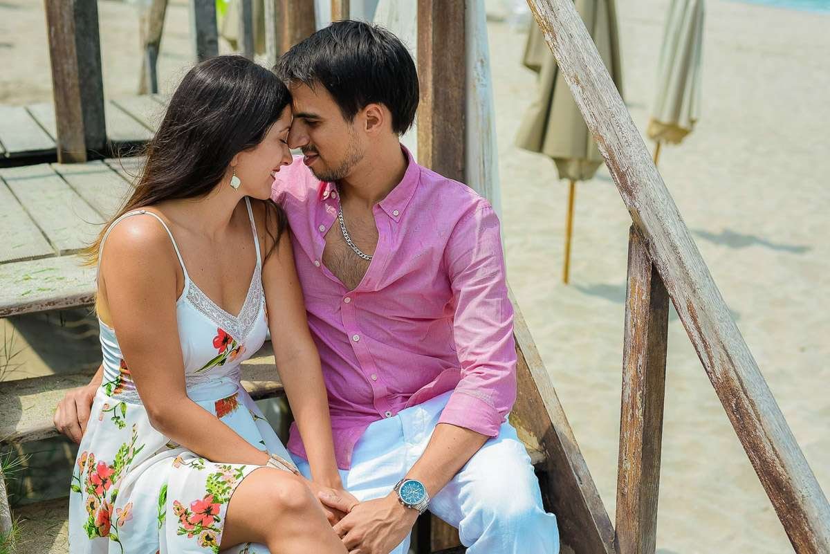 Pareja sentada muy cerca en las escaleras, a punto de besarse