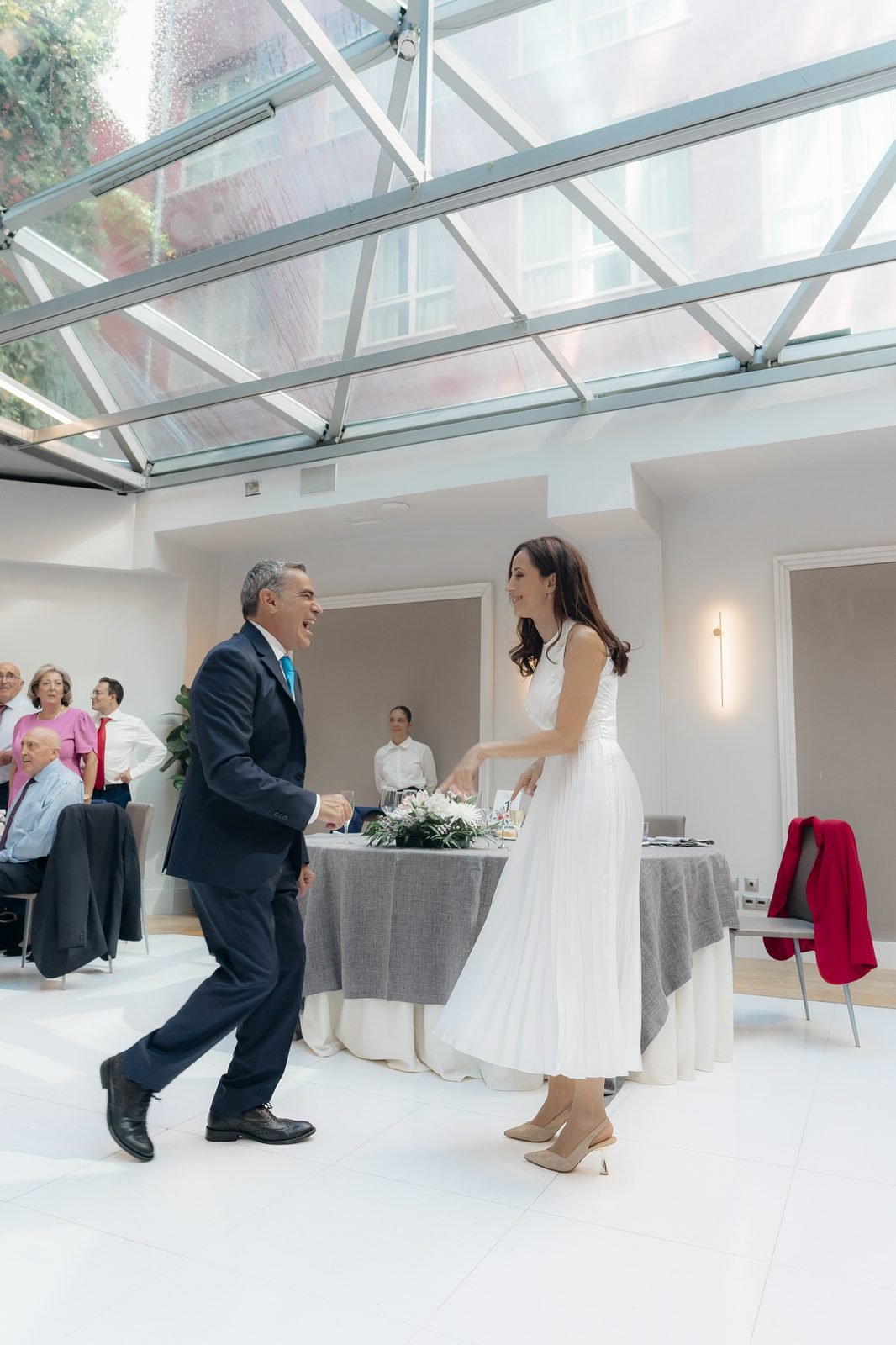 Los novios cruzando el salón acristalado del Hotel Santo Domingo, con la luz entrando por la cubierta