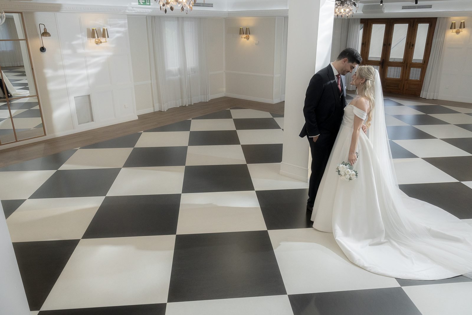 El salón de Finca Monteviejo con suelo de damero blanco y negro, la novia entrando